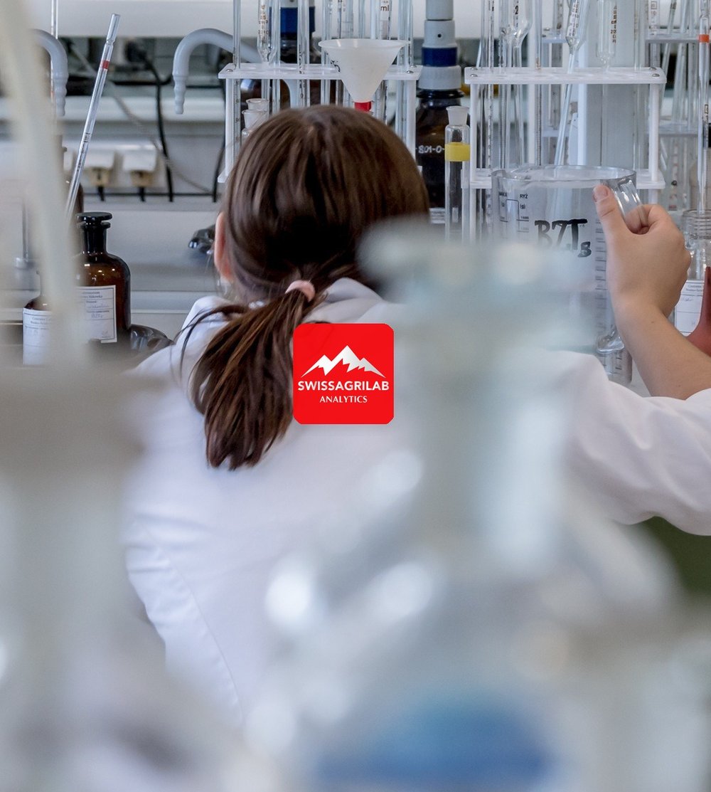 SwissAgrilab chemist analysing samples, wearing a lab coat with the SwissAgrilab logo